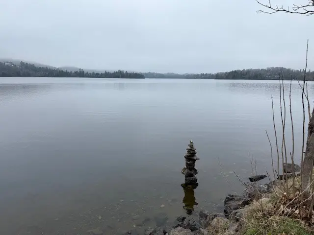 Photo qui illustre l'Hypervigilance - lac sous la brume avec un inukshuk