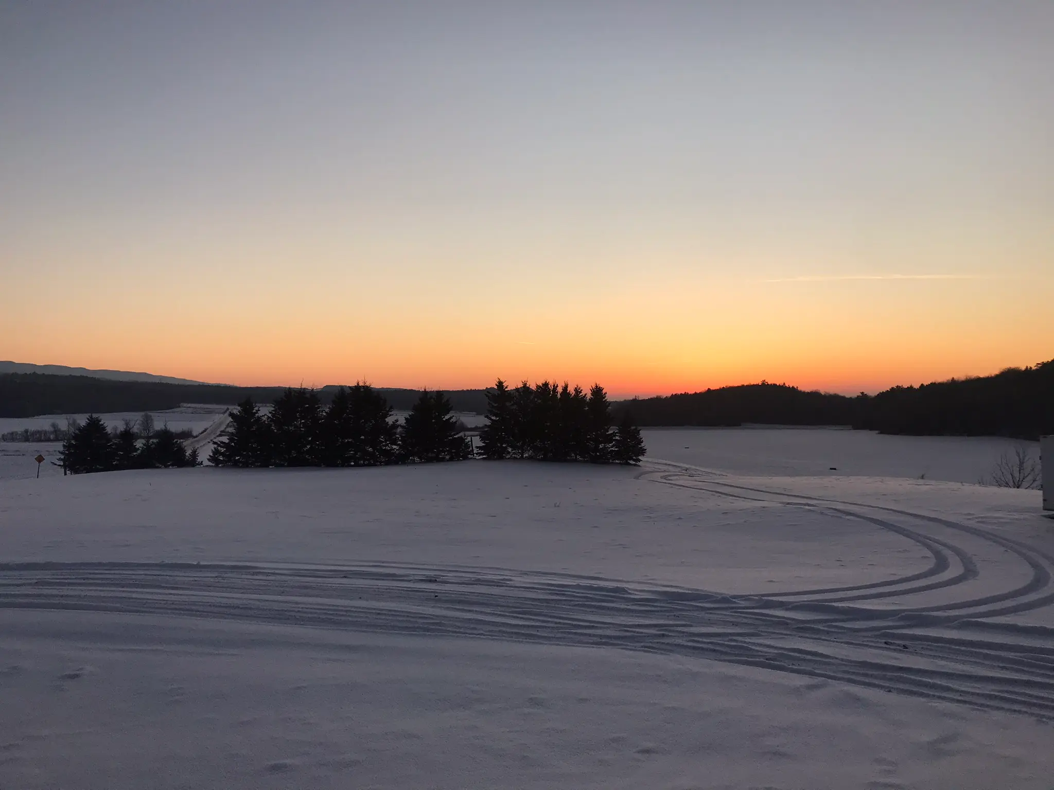 Photo d'un coucher de soleil avec deux chemins dans la neige celui traditionnel et celui hors piste pour symboliser la neurodivergence